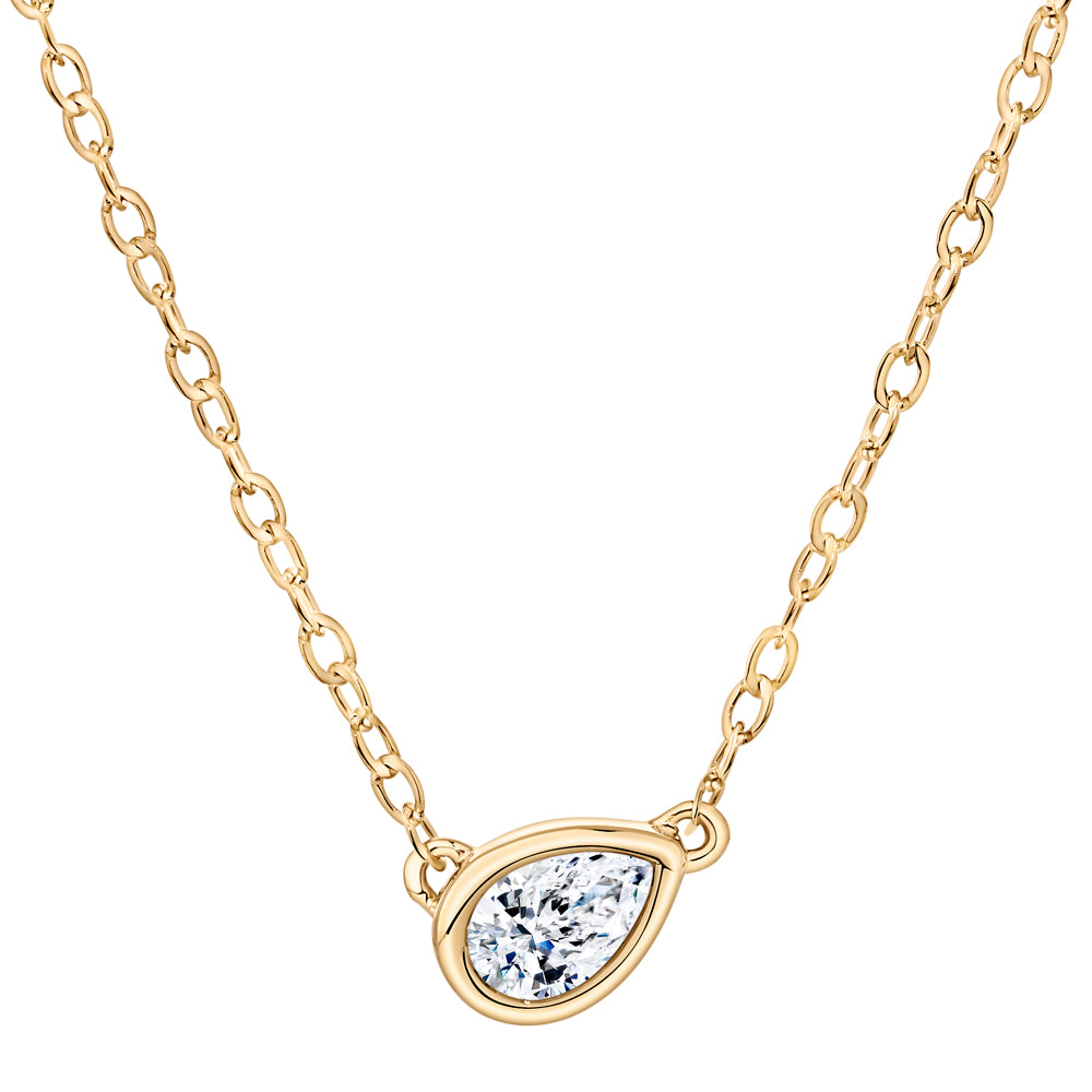 A gold chain necklace with a teardrop-shaped bezel setting holding a clear pear-cut gemstone, shown on a plain white background.