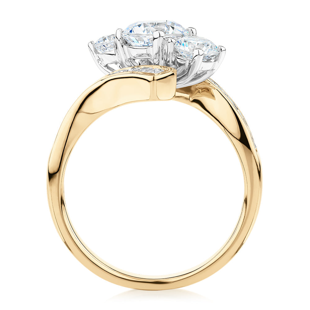 Three stone ring with 2.63 carats* of diamond simulants in 10 carat yellow and white gold