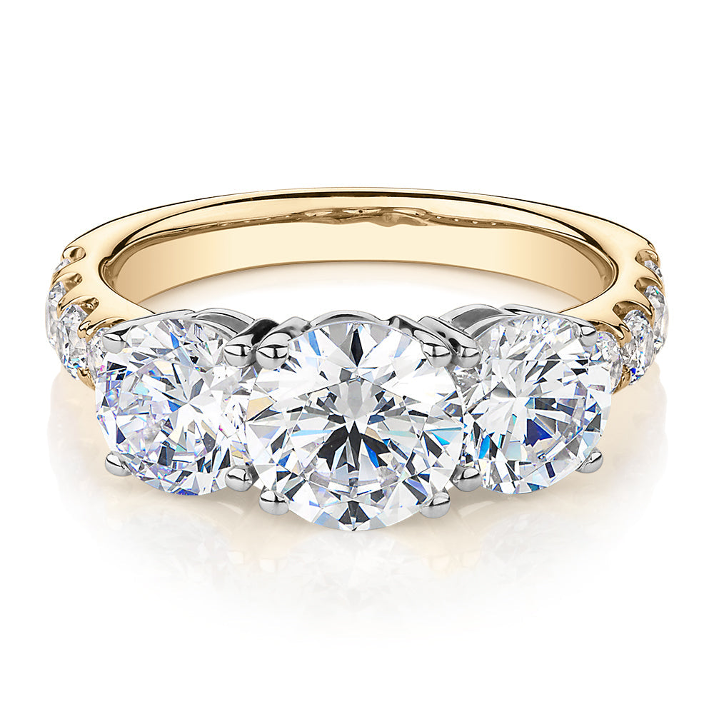 Three stone ring with 3.44 carats* of diamond simulants in 10 carat yellow and white gold