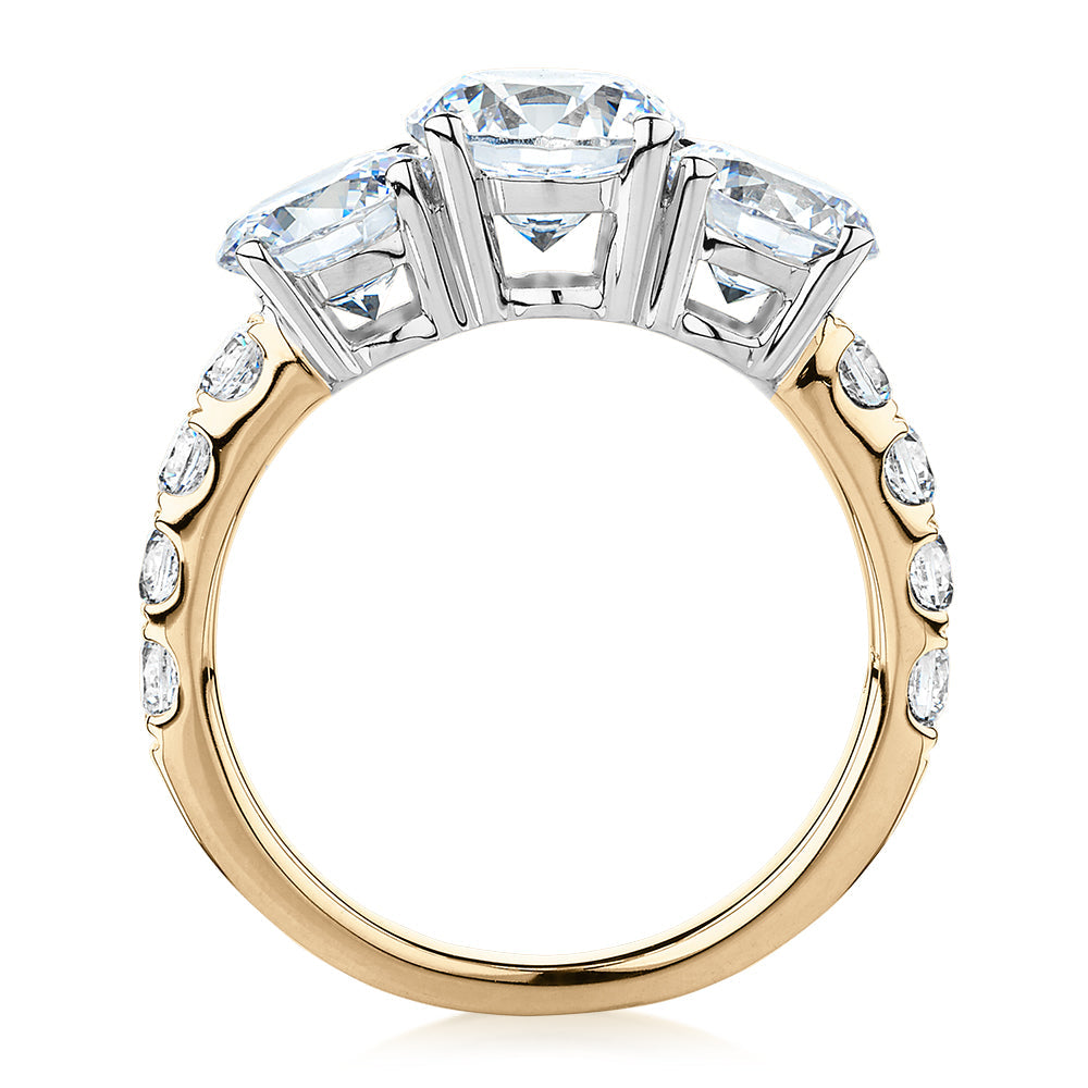 Three stone ring with 3.44 carats* of diamond simulants in 10 carat yellow and white gold