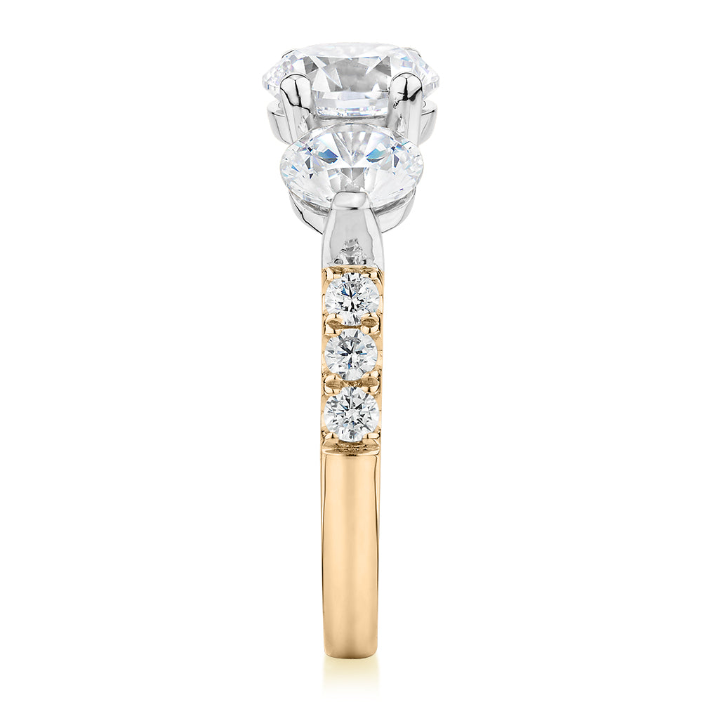 Three stone ring with 3.59 carats* of diamond simulants in 10 carat yellow and white gold