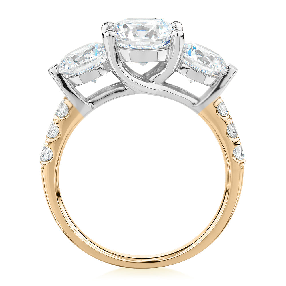 Three stone ring with 3.59 carats* of diamond simulants in 10 carat yellow and white gold