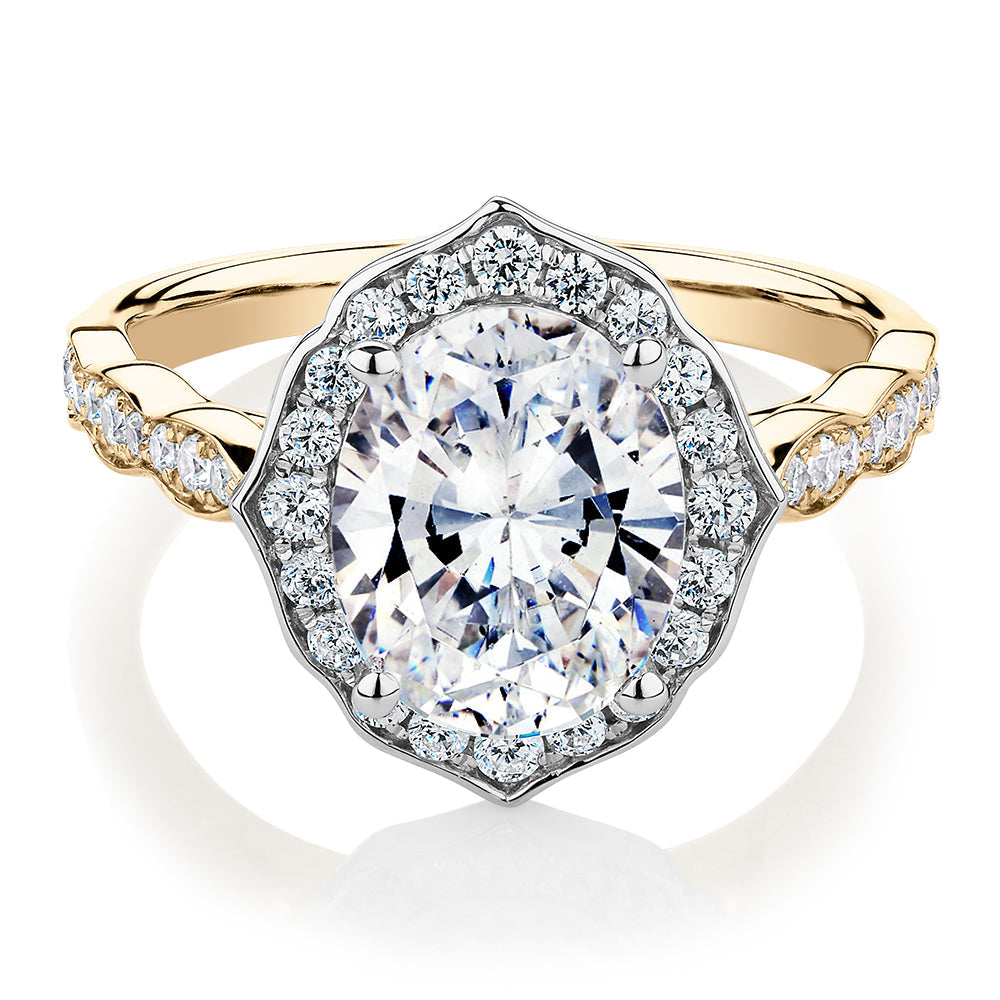 Oval and Round Brilliant halo engagement ring with 2.86 carats* of diamond simulants in 14 carat yellow and white gold