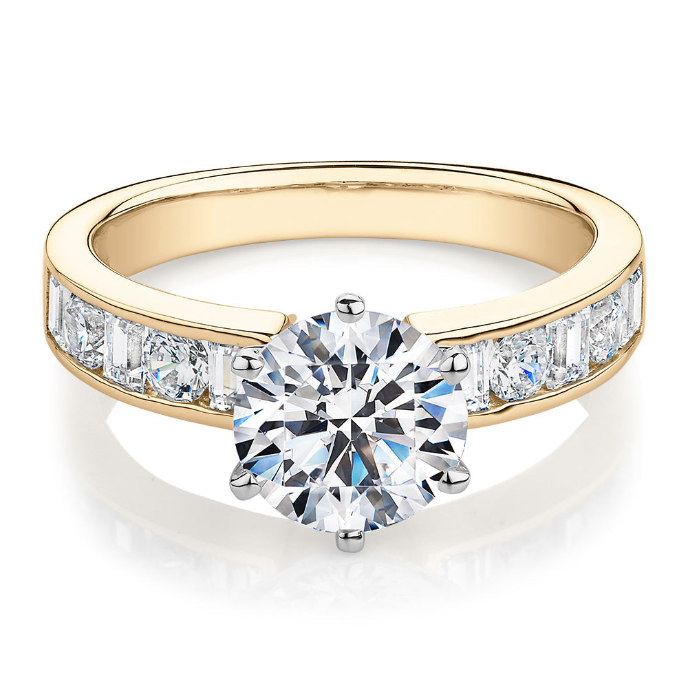 Round Brilliant and Baguette shouldered engagement ring with 2.72 carats* of diamond simulants in 14 carat yellow and white gold